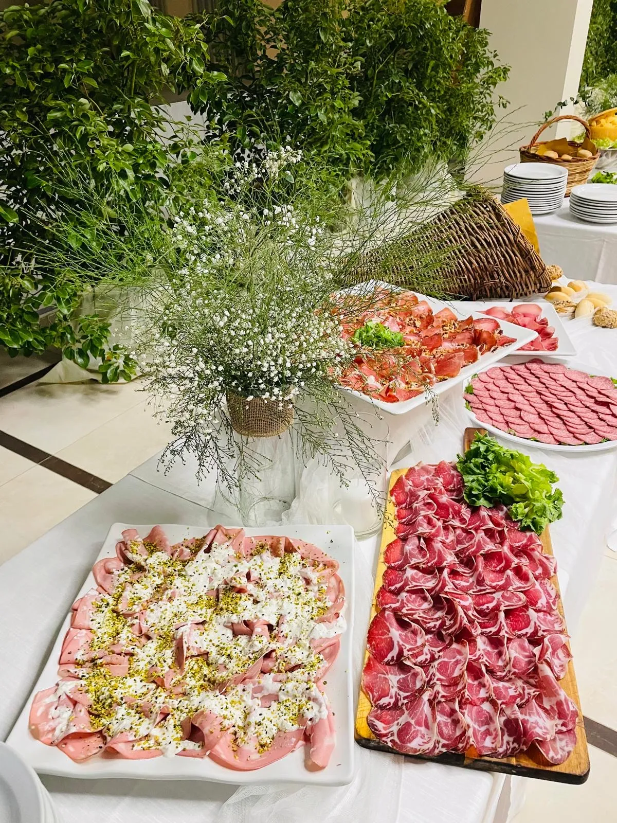 Buffet di salumi misti con vassoi di affettati e pani artigianali allestito in sala da Buratti Catering