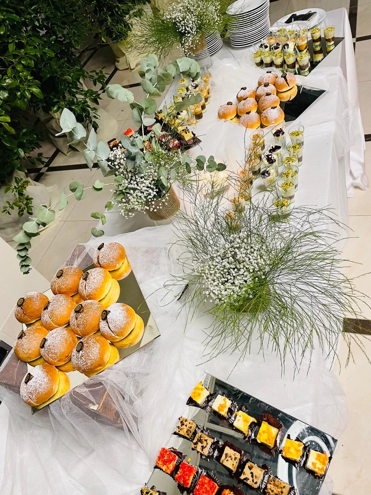 Tavolo dessert Buratti Catering con monoporzioni in bicchiere e dolci lievitati su specchi e tulle bianco