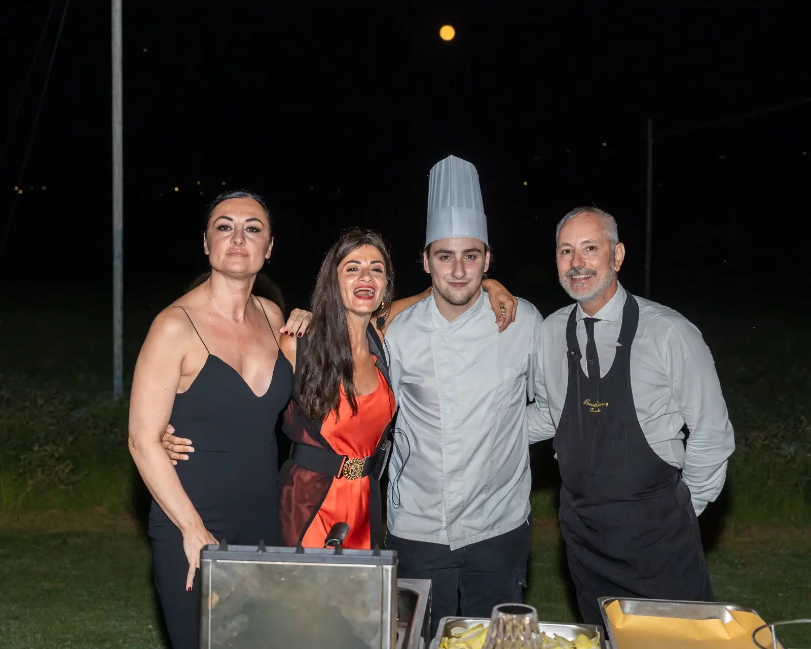 Gruppo vicino alla postazione di servizio con luna piena sullo sfondo