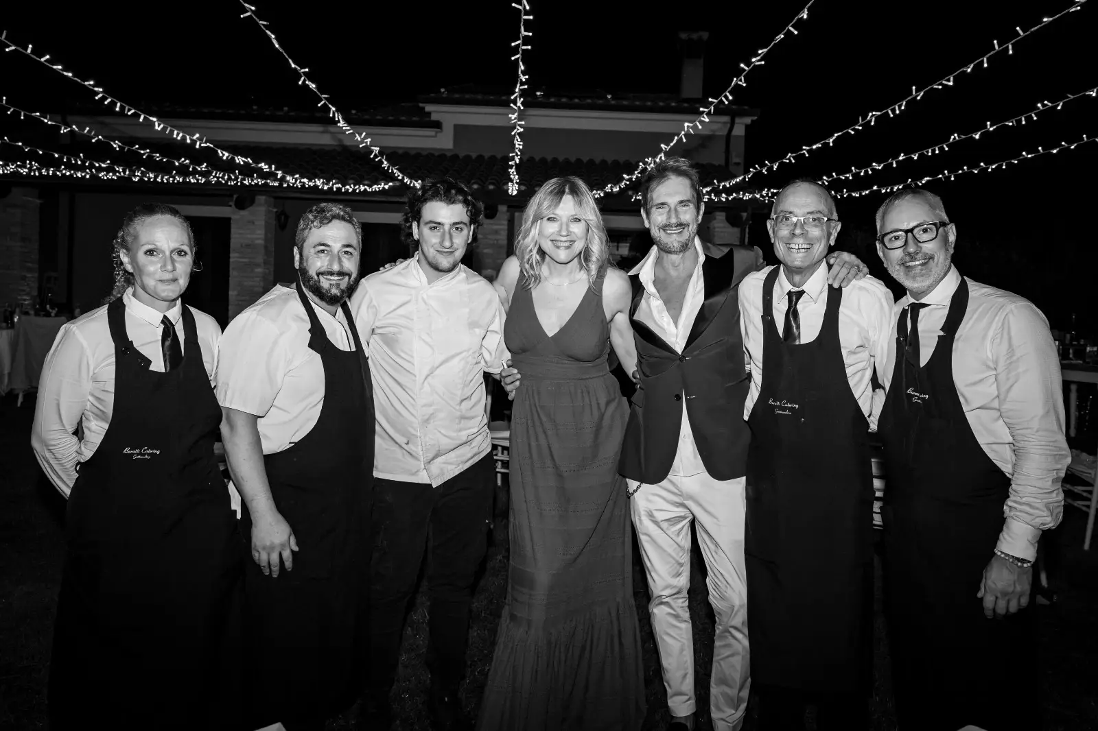 Foto di gruppo in bianco e nero sotto le luci decorative