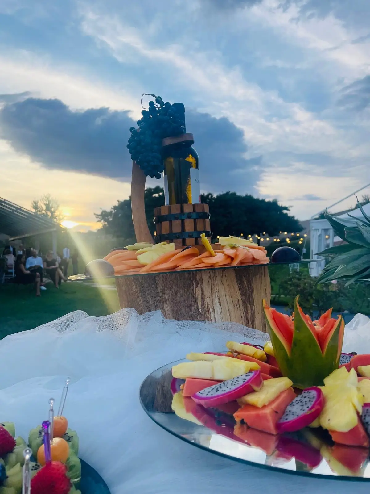 Composizione rustica con frutta uva bottiglie di vino e pane su tavolo in legno