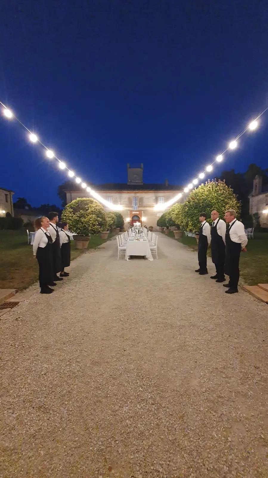 Staff allineato dietro al tavolo buffet centrale prima dell'arrivo ospiti