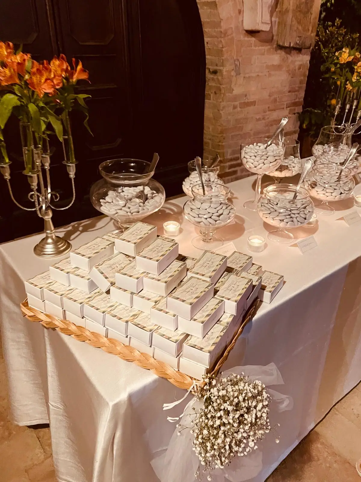 Tavolo confettata con vasi di confetti candele accese e bomboniere coordinate