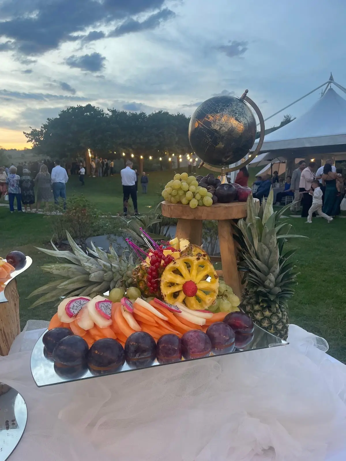 Buffet frutta oro con ananas melone prugne e uva su specchi lucidi