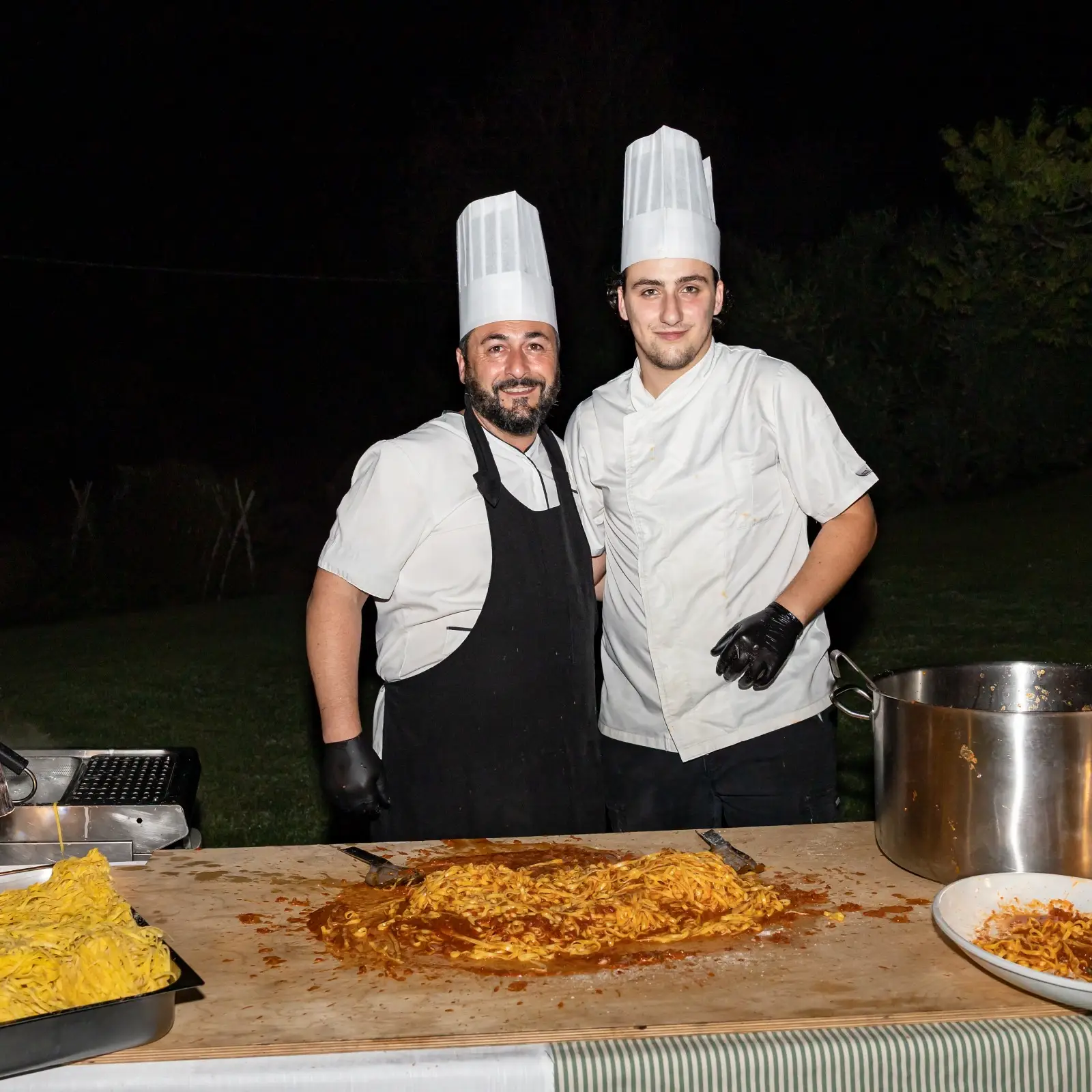Postazione pasta con due cuochi al banco che preparano primi fumanti